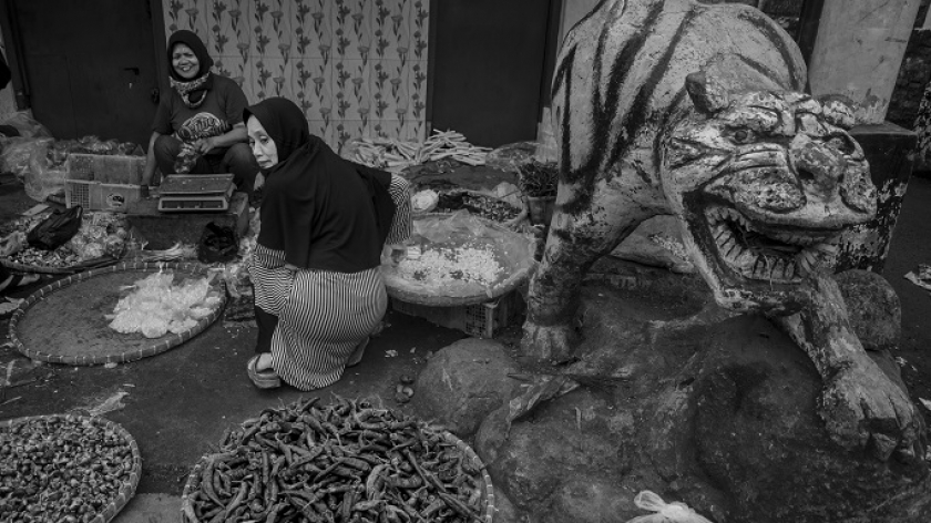 Enung (45), salah satu pedagang Pasar Cicadas, sedang melayani pembeli, Senin (17/5/2021). Setiap hari waktu berjualan para pedagang dibatasi hingga pukul 7 pagi. (Foto: Arbi Ilhamsyah)