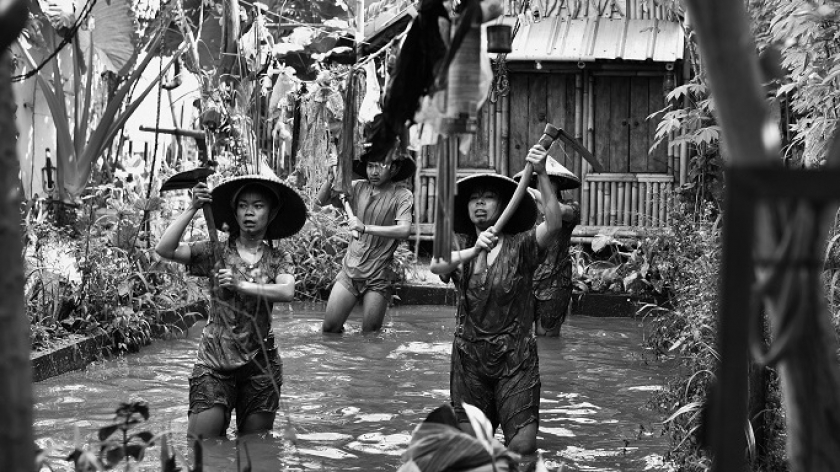 Pemeran petani yang menari di atas balong yang mengibaratkan bekas garapan sawah, dalam pertunjukan seni Ciganitri Kiwari, Minggu (19/03/2023). (Foto: Dini Putri/BandungBergerak.id)