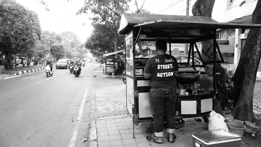 Berjualan di pinggiran jalan membuat Yandi berhadapan langsung dengan kerasnya hidup di Bandung. Berulang kali ia harus merelakan sebagian hasil jerih-payahnya diberikan sebagai japrem. (Foto: Bani Hakiki)