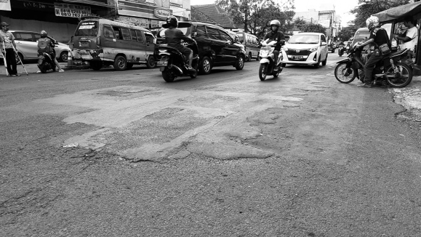 Badan jalan bergelombang akibat berulang kali tambalan aspal di Jalan Pungkur, Kota Bandung, Kamis (25/5/2023). (Foto: Awla Rajul/BandungBergerak.id)