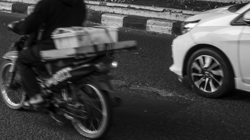 Pengendara melintasi jalan berlubang yang posisinya tepat di tengah-tengah jalan di Kota Bandung. (Foto: Virliya Putricantika /BandungBergerak.id)