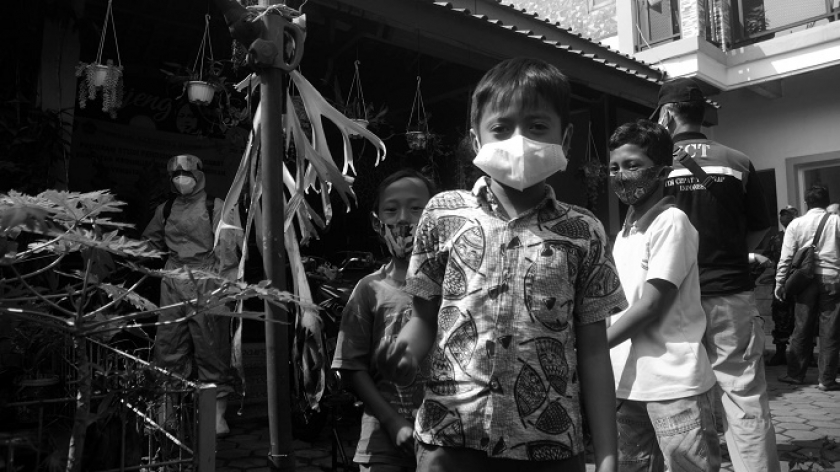 Anak-anak di tengah Satgas Covid-19 yang melakukan disinfeksi kampung saat penerapan PPKM mikro di Desa Cigending, Kecamatan Ujungberung, Bandung, Jawa Barat, terkait terbentuknya klaster penularan Covid-19 di Kelurahan Cigending,11 Juni 2021. (Foto: Prima Mulia)  