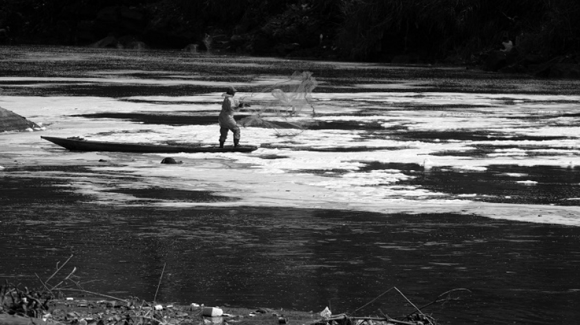 Warga menjaring ikan di Sungai Citarum yang kotor. Debit air Citarum terus menyusut, Minggu (23/7/2023). (Foto: Prima Mulia/BandungBergerak.id)