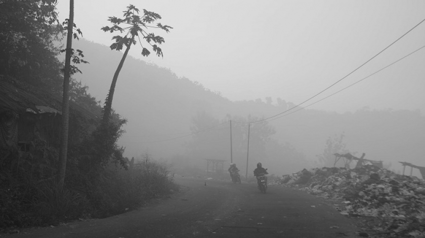 Kabut asap akibat kebakaran TPA Sarimukti menyerang jalan dan permukiman warga di Kabupaten Bandung Barat, Kamis (24/8/2023). (Foto: Prima Mulia/BandungBergerak.id)