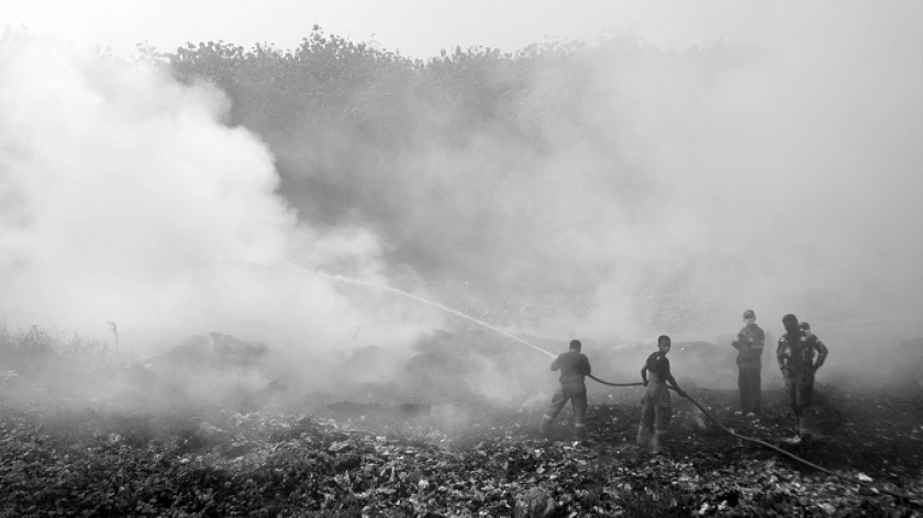 Petugas pemadam kebakaran di tengah kabut asap di area pembuangan sampah akhir yang terbakar di TPA Sarimukti, Kabupaten Bandung Barat, Rabu (23/8/2023). (Foto: Prima Mulia/BandungBergerak.id)