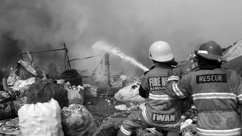 Petugas pemadam kebakaran menyemprot air ke titik api baru di zona 2 TPA Sarimukti, Kabupaten Bandung Barat, Kamis (24/8/2023). (Foto: Prima Mulia/BandungBergerak.id)