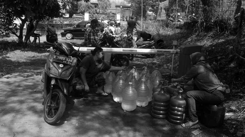 Warga mengisi air ledeng ke galon-galon kosong di halaman perusahaan daerah air minum pelat merah Perumda Tirta Raharja, Cimahi, Senin, 16 Oktober 2023. (Foto: Prima Mulia/BandungBergerak.id)