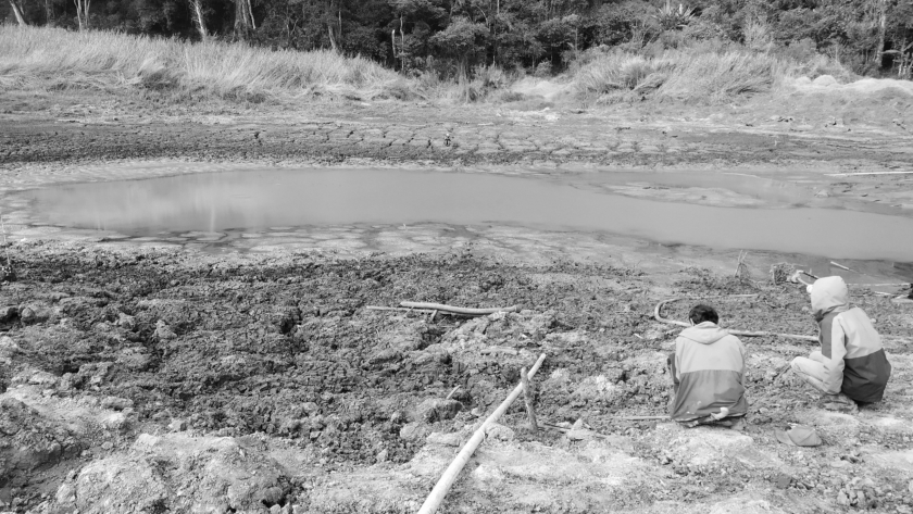 Warga memancing ikan di Situ Aul, lokasi yang dulunya keramat, dengan volume air yang jauh menyusut akibat kemarau panjang, Senin 14 Oktober 2023. (Foto: Akmal Firmansyah/BandungBergerak.id)