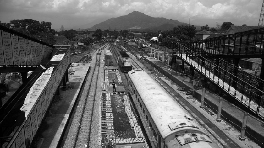 Kereta api berhenti di bawah bangunan skybridge Stasiun Cicalengka, Kabupaten Bandung, Minggu, 7 Januari 2024. (Foto: Prima Mulia/BandungBergerak.id)