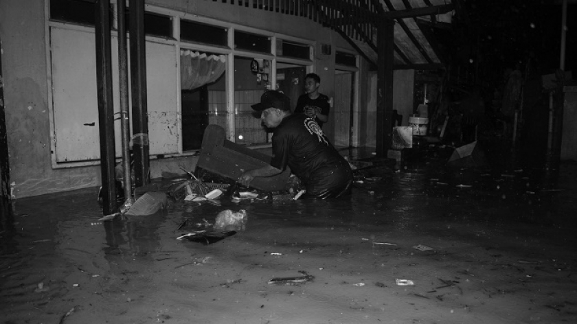 Warga mengevakuasi motor yang terendam dalam bencana banjir di Gang Kampung Braga, Bandung, Kamis, 11 Januari 2024. (Foto: Prima Mulia/BandungBergerak.id)