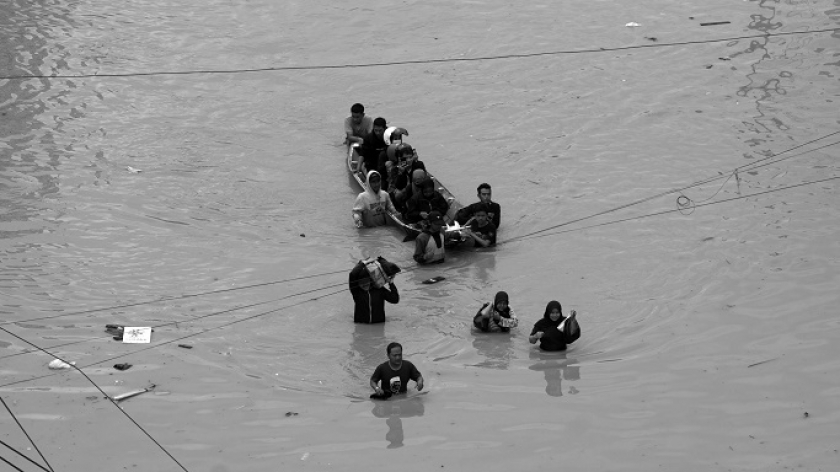 Perahu dan pejalan kaki melintas di Jalan Raya Dayeuhkolot,  Kabupaten Bandung, Kamis, 12 Januari 2024. (Foto: Prima Mulia/BandungBergerak.id)