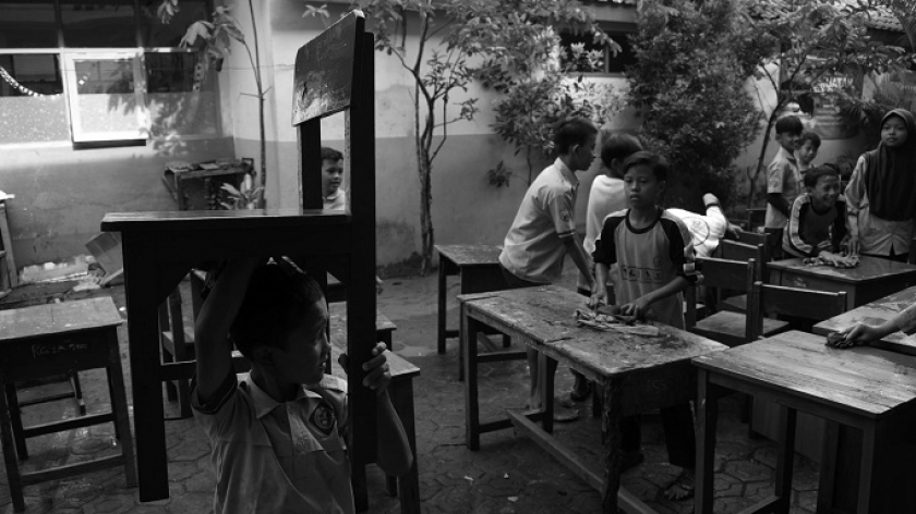 Murid dan guru SDN Leuwibandung 3 membawa kursi yang sudah dicuci pascabanjir besar di Desa Citeureup, Kecamatan Dayeuhkolot, Kabupaten Bandung, 15 Januari 2024. (Foto: Prima Mulia/BandungBergerak.id) 