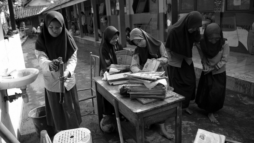 Murid SDN Leuwibandung 3 mencuci meja kursi pascabanjir di Desa Citeureup, Kecamatan Dayeuhkolot, Kabupaten Bandung, 15 Januari 2024. (Foto: Prima Mulia/BandungBergerak.id) 