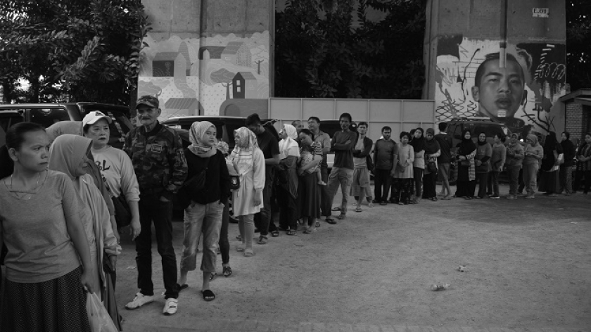 Warga Kecamatan Bandung Wetan antre untuk membeli beras dan bahan pangan murah di kolong jembatan layang Mochtar Kusumaatmadja, Bandung,  19 Februari 2024. (Foto: Prima Mulia/BandungBergerak.id)