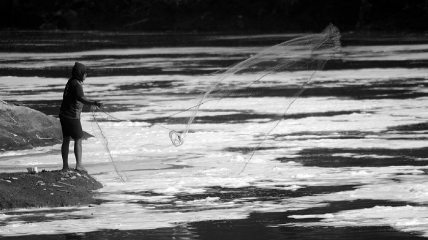 Warga  mencari ikan di aliran Sungai Ci Tarum yang tercemar, Desa Jelegong, Kecamatan Kutawaringin, Kabupaten Bandung, 25 Agustus 2021. (Foto: Prima Mulia/BandungBergerak.id)