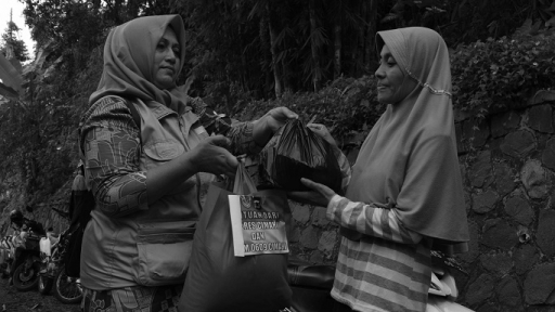 Warga Kampung Cigombong menerima bantuan paket sembako di Desa Cibedug, Kecamatan Rongga, Kabupaten Bandung Barat, 4 Maret 2024. (Foto: Prima Mulia/BandungBergerak.id)