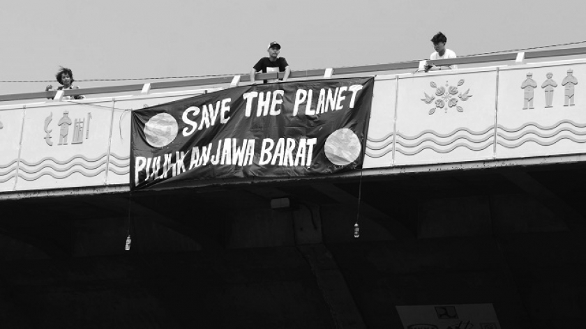 Aktivis lingkungan membentang sepanduk saat aksi Hari Bumi di kawasan Dago Cikapayang, Bandung,  22 April 2024. (Foto: Prima Mulia/BandungBergerak.id)